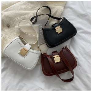 Detailed view of three minimalist leather armpit bags with elegant gold metal buckles