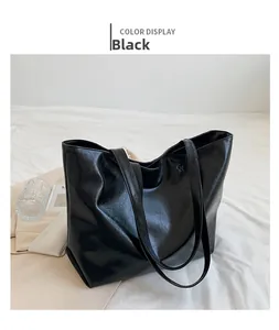 Vue détaillée du grand sac cabas noir à texture vintage sur un fond en tissu blanc doux
