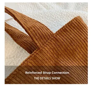 Détail de couture renforcée de la bandoulière sur le sac cabas en velours côtelé marron