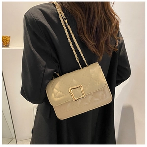 Detail of beige quilted crossbody bag with gold square buckle and leather chain strap