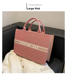 Gros plan du grand sac cabas en toile rose avec imprimé de lettres M et texte mode