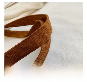 Détail de la bandoulière en velours côtelé marron et de la texture du sac fourre-tout