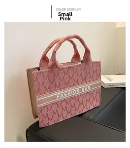 Détail macro du sac cabas en toile rose avec motif jacquard et doubles poignées
