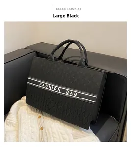 Détail du sac cabas noir avec jacquard à motif M et texte Fashion Bag sur un canapé
