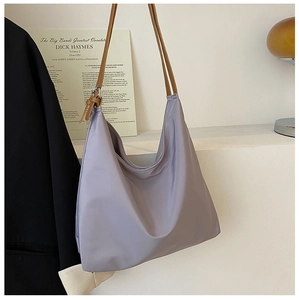 Détail du sac hobo lilas avec bandoulière en cuir marron et boucle en métal argenté