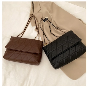 Détail de sacs bandoulière matelassés noir et marron avec chaîne dorée et veste de tailleur