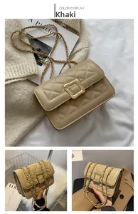 Close-up of khaki quilted crossbody bag with gold square buckle and chain strap