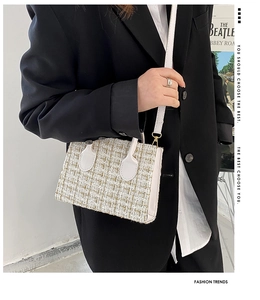 Dettaglio di una borsa a tracolla in tweed bianco con manico e fibbia in metallo