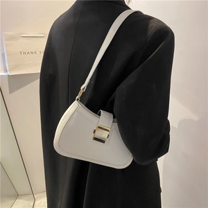 Minimalist white leather underarm bag with gold buckle on a black blazer outfit