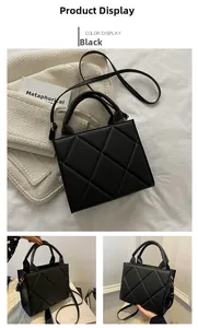 Detail view of black quilted crossbody bag with top handle and adjustable strap