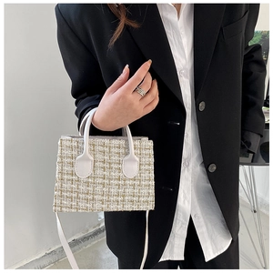 Dettaglio della borsa in tweed con manici in pelle bianca e tracolla sottile