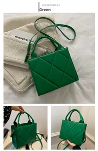 Close-up of a green quilted handbag with textured leather and cylindrical top handles