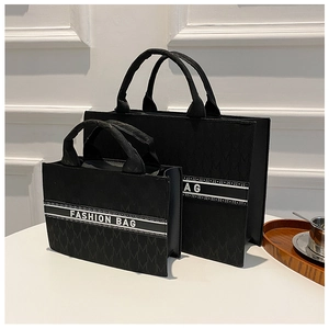 Détail de sacs cabas en jacquard noir avec motif M et bande de texte tendance