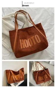 Macro detail of brown faux suede tote bag featuring stitched HOOTO leather letters