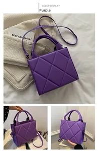 Detail of purple quilted crossbody bag with dual handles and elegant rhombic pattern