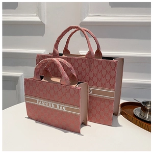 Vue détaillée des sacs cabas en toile rose avec jacquard et texte de mode central