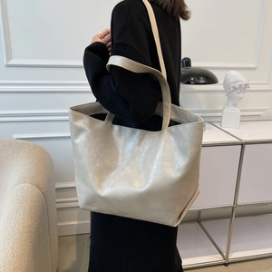 Sac fourre-tout beige minimaliste en cuir PU de grande capacité porté par un mannequin