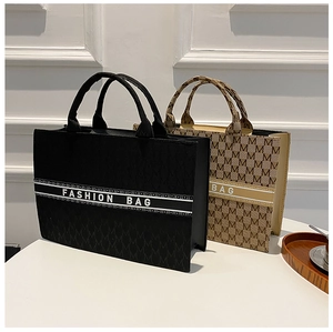 Détail du sac fourre-tout chic en toile avec broderie motif M et sangle tendance