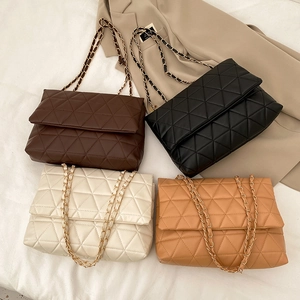 Sac bandoulière matelassé en quatre couleurs sur fond de blazer beige