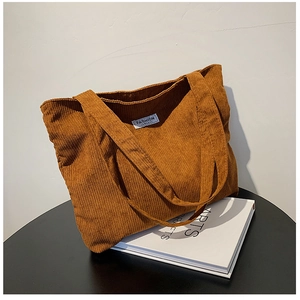 Détail du sac fourre-tout en velours côtelé marron avec étiquette blanche fashion instinct