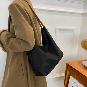 Sac fourre-tout minimaliste en oxford noir avec bandoulière en cuir marron sur modèle