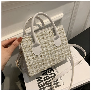 Dettaglio della borsa a tracolla in tweed con accenti dorati e manico in ecopelle bianca
