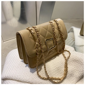 Close-up of khaki quilted crossbody bag featuring golden square buckle and chain strap