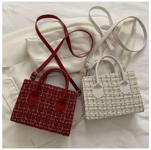 Dettaglio ravvicinato di mini borse in tweed scozzese rosso e beige con fibbie d'oro