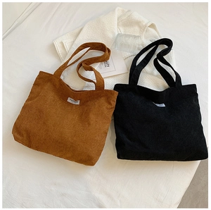 Détail de la texture en velours côtelé et étiquette de mode sur sacs marron et noir