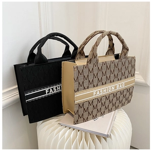 Détail du sac cabas en toile avec monogramme M et inscription Fashion Bag en gros plan