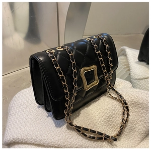 Detail view of black quilted crossbody bag with gold chain and accordion side structure