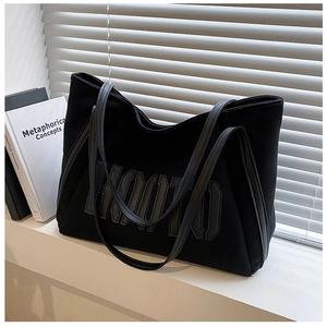 Detail of black suede tote bag with HOOTD embossed letters and long shoulder straps