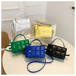 Detail of quilted tote bag set in white yellow green blue and black faux leather