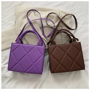 Detail view of quilted square crossbody bags in purple and brown PU leather