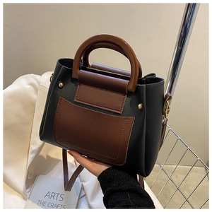 Detail of a vintage-style patchwork crossbody bag with a round tortoiseshell handle