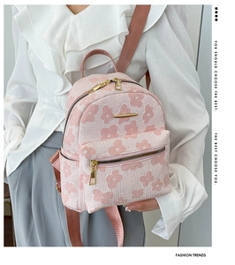Détail du sac à dos en jacquard rose à motif floral avec finitions en métal doré