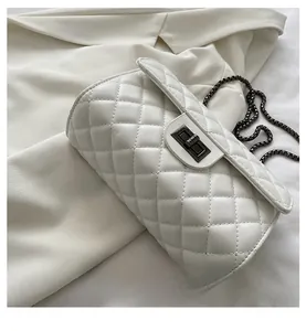 Detailed view of the quilted texture and base of the white chain shoulder bag