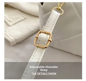 Détail de la bandoulière réglable et boucle dorée sur le sac matelassé blanc