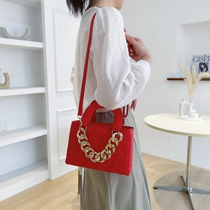 Quilted red crossbody bag with chunky gold chain handle and leather shoulder strap