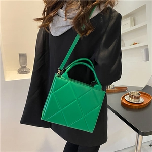 Quilted green crossbody bag with elegant top handle and minimalist square leather design