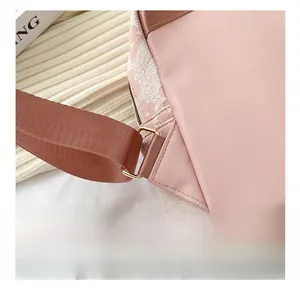 Vue détaillée de la couture triangulaire et de l'anneau en D doré sur le sac rose