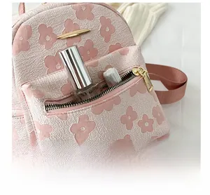 Détail du mini sac à dos en toile rose avec une poche frontale zippée fonctionnelle