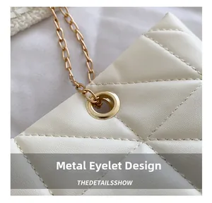 Détail macro du sac en cuir blanc matelassé avec œillet élégant en chaîne dorée