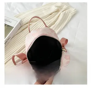 Détails du sac à dos fleuri rose montrant l'espace intérieur noir et le zip doré