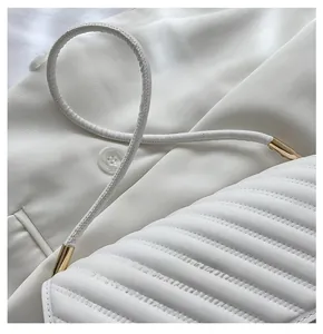 Close-up of white quilted leather bag featuring comfortable straps and golden hardware