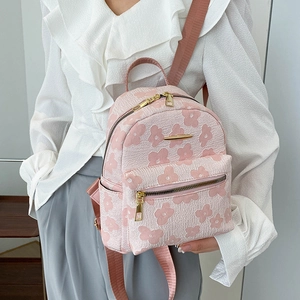 Gros plan du sac à dos en toile à fleurs roses montrant le tissu et les poches de côté