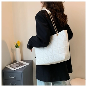 Détail du grand sac cabas blanc matelassé avec motif géométrique et bandoulière chaîne