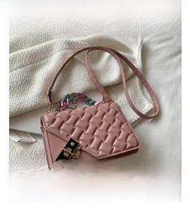Detailed view of pink quilted handbag with gold clasp and acrylic chain strap