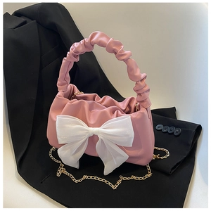 Detailed macro view of a pink pleated handbag featuring a large white chiffon bow and chain