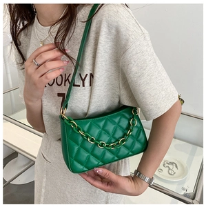 Détail du sac sous le bras vert matelassé avec chaîne en résine et coutures fines